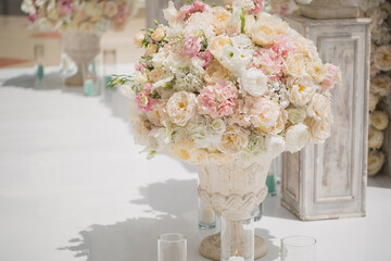 Beautiful bouquet of roses in a vase on a background of a wedding arch. Beautiful set up for the...