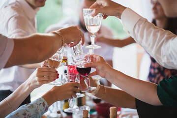 People clang glasses sitting at dinner table in sparkling lights