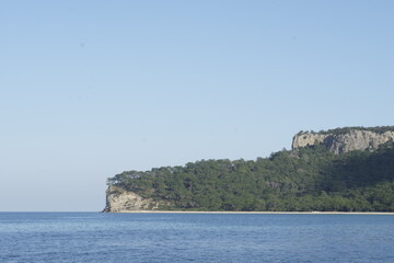 Fototapeta na wymiar View of peninsula covered with tree reaching into the sea