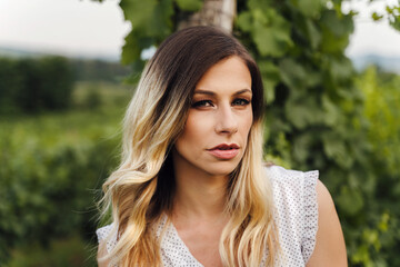 Fototapeta premium Front view on caucasian woman standing outdoor - Close up portrait of beautiful adult female in summer evening or day in nature - Real people contemplation solitude concept