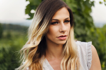Naklejka premium Front view on caucasian woman standing outdoor - Close up portrait of beautiful adult female in summer evening or day in nature - Real people contemplation solitude concept