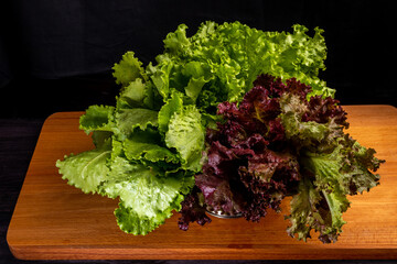 fresh green and red lettuce on wooden cutting board