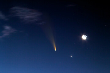 Night blue sky with bright moon and Neowise comet with light tail. © bilanol