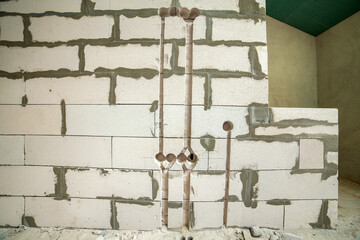 Deep grooves and holes in white brick wall made for installation of electrical cables.