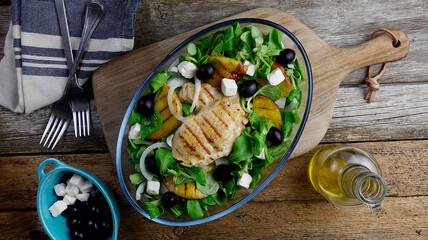 healthy grilled chicken salad with nectarines, olives, feta cheese, and lamb's lettuce