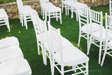 Beautiful white wedding chairs at the ceremony in the Park.