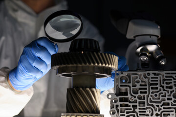 Man in lab examines parts of vehicle