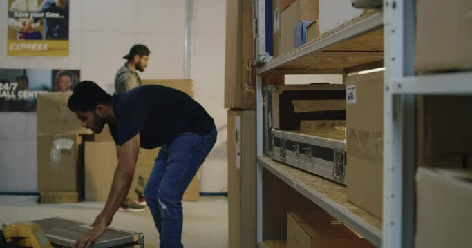Worker placing road cases on shelves