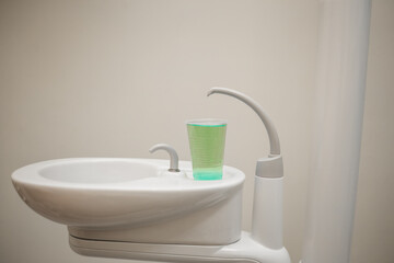 Fototapeta na wymiar Sink with a glass of water in the dental office