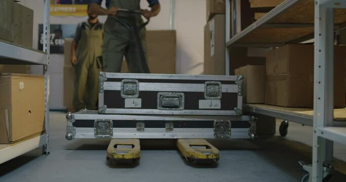 Worker placing road cases on shelves