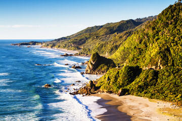 New Zealand Coastal Highway: A scenic road winds along the western shore of New Zealand's South Island