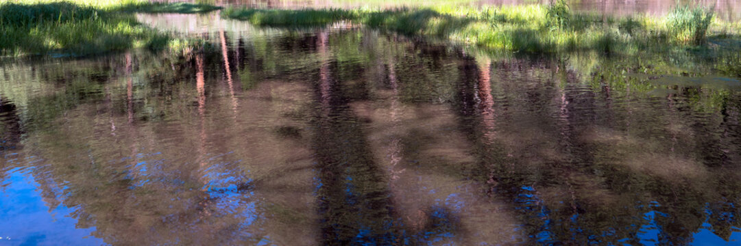 Panorama of refections at dawn on Cimarron River at Cimarron Canyon State Park in New Mexico