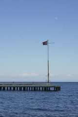 Turkish flag on flag pole over the empty pier
