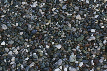 Closeup view of small stones on the beach with colorful pattern