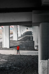 Runner standing under the bridge and holding arms crossed.