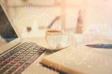Double exposure of financial chart drawing and desktop with coffee and items on table background....