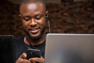 young black man working with his laptop smiling