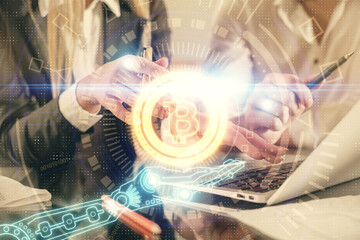 Double exposure of man and woman working together and crypto finance theme hologram. Blockchain business concept. Computer background.