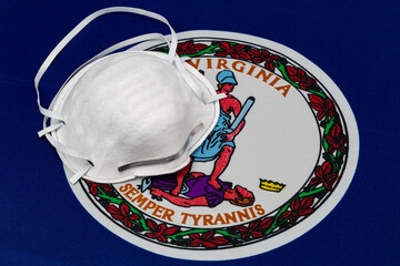 Virginia state flag and N95 face mask. Concept of state and local government face covering mandate,...