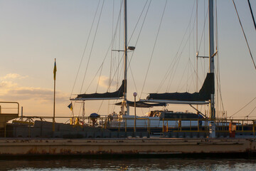 Evening in a quiet bay. Moored yachts in the port. Windless sunset in the bay.