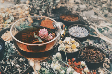 Toned image of healthy herbal tea on medicinal flowers and herbs background, selective focus © ulada