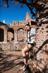 A girl stands against a brick wall