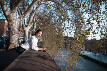 a young woman stands by the river