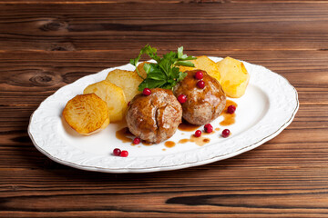 cutlets and fried potatoes on a wooden background