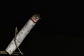 Burning cigarette on black