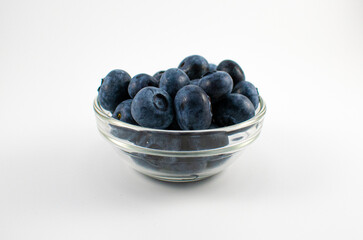 Close up photo of a glass bowl full of blueberries