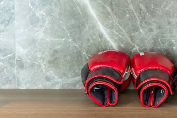 Boxing gloves that are placed on Wooden shelf in the gym.