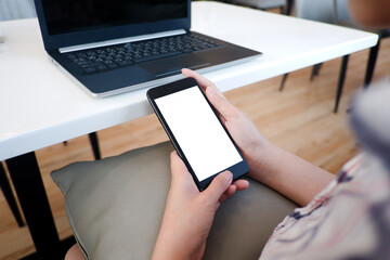Cropped shot view of woman’s Hands hold the smartphone with blank copy space screen for your information content or text message on the gray granite at the modern place.