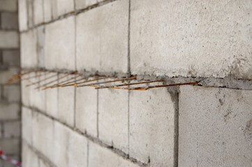 gray brick wall with iron bars reinforcement during construction