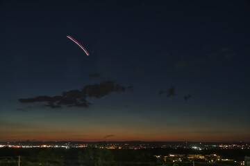 Comet Neowise in the night sky over a city at dusk