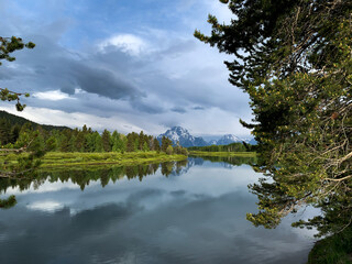 Grand Teton Range and Clouds Reflected in Lake and Surrounded by Trees - Early Morning - Wyoming, USA