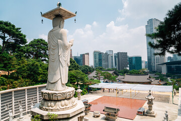 Buddha statue with modern cityscape at Bongeunsa temple in Seoul, Korea