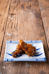 Sour-sweet baked chicken wings sesame and  teriyaki sauce.
