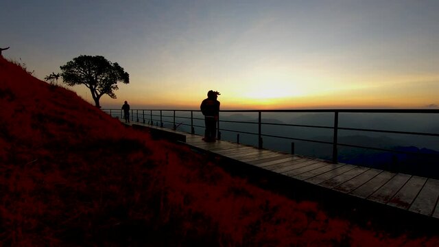Time Lapse silhouette Walkway bridge along the hill with tourists at Doi Pui Co moutain, view point in Sop Moei, Mae Hong Son, Thailand.