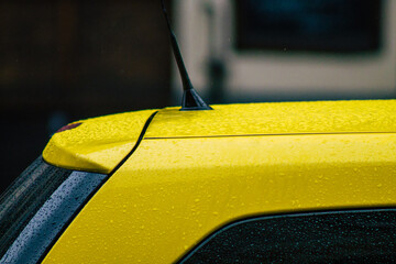 View of a traditional yellow Hungarian taxi for passengers driving under the rain through the...