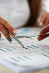 Female arm holding silver pen point in financial graph solving and discussing problem with colleague closeup. Situation examination at board council sale adviser job stock exchange market profit