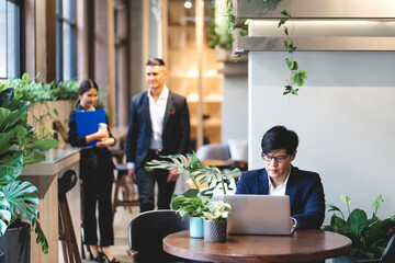 Group of professional business discussing meeting strategy sharing ideas thoughts with project.Creative business people working with laptop computer in green plant terrace decorated modern workloft