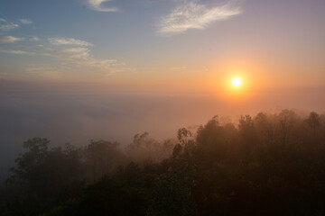 The sun rises through the mist on the Glass House  Mountains, Queensland, Australia