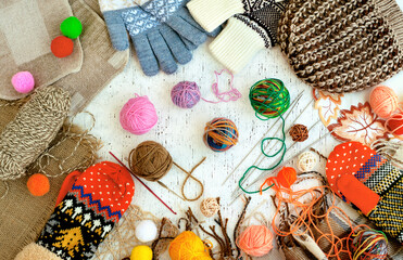 Knitting yarn and knitted garments. Needlework and knitting hobbies. Colorful multi-colored yarn for knitting warm clothes.