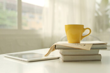 yellow coffee cup Workplace with white laptop, notebook and coffee on wooden desk .Coffee cups...
