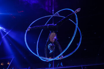 Flexible young woman make performance on aerial hoop, flexible back on aerial hoop, aerial circus...