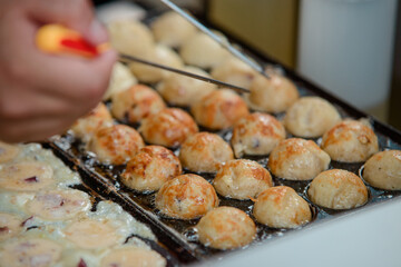 Takoyaki balls being cooked in a pan