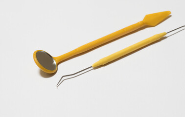 Yellow color dentist tools on white background.