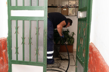 Worker cleans the drains hatch and removes dirt and debris from the sewer. Plumber cleans the sewer