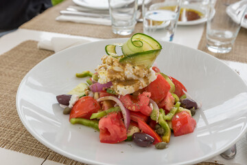 Greek salad with feta tomato onion peppers olives capers and zucchini