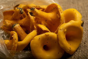 A pile of curly cookies in the form of chanterelle mushrooms on a homespun fabric with a rough texture. Close up.